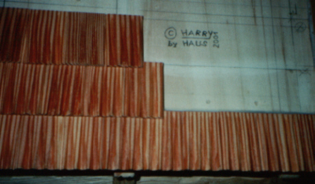 Die Dachschindeln mit heller Politur streichen, trocknen lassen und oben an den Dachteilen sowie unten auf der fertigen Dachschindelreihe, so verleimen, damit noch 47mm von der Unteren Reihe zu sehen sind